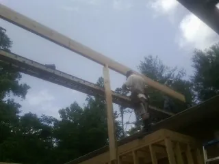 Carpenter setting a ridge beam over a new addition frame — Ice Dam Removal by Roofing Brothers in Blackville