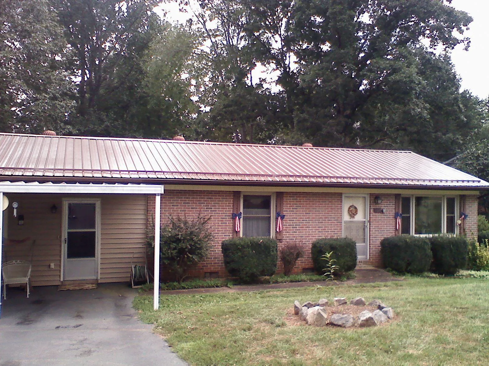 Bronze metal roof and carport on a brick ranch home — Roof Repair work by our crew in Blackville